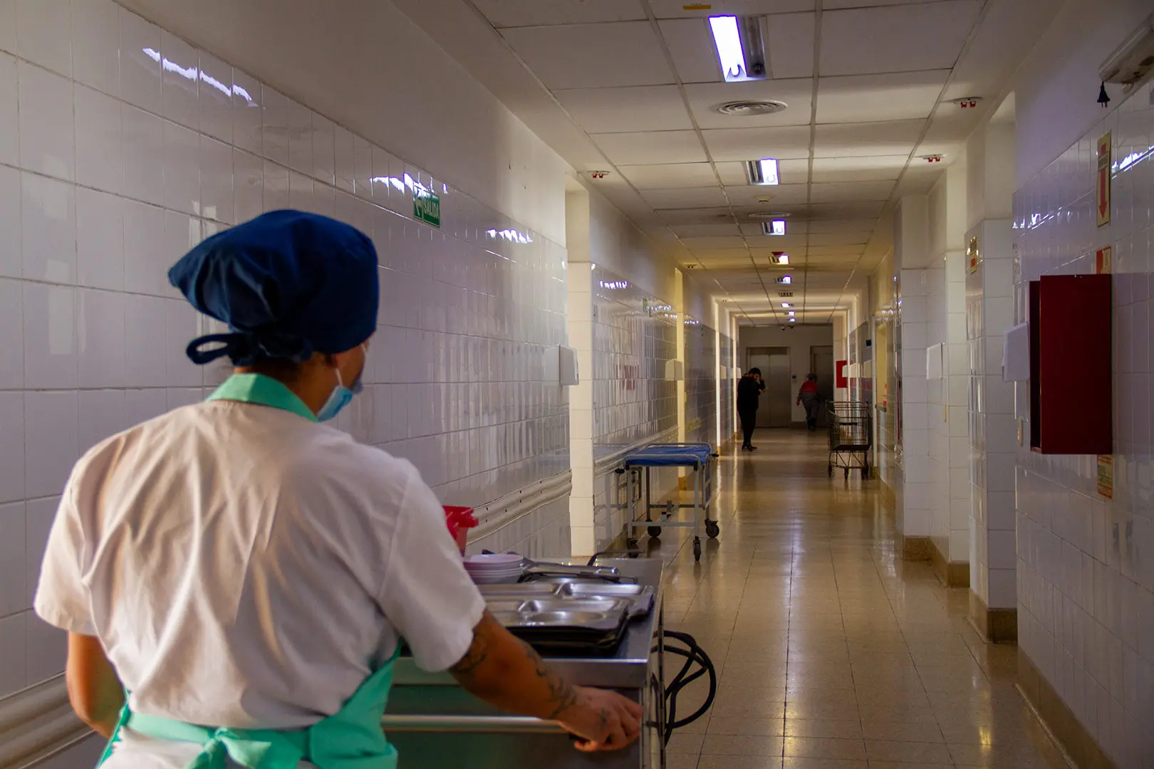 Personal de SASA trasladando un carro de comida por el pasillo de un hospital