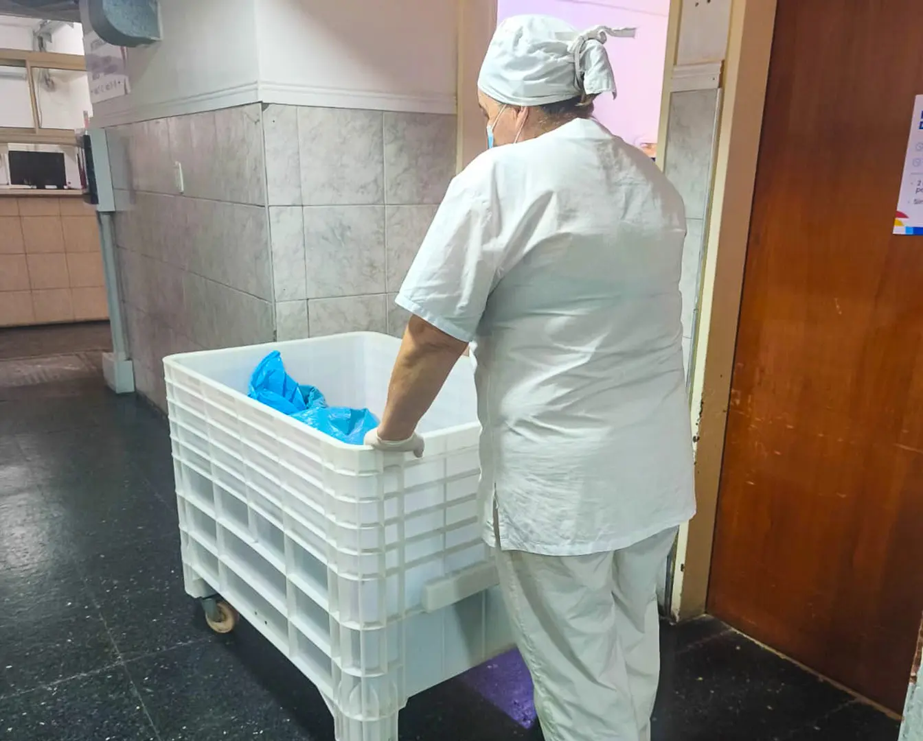 Personal de SASA trasladando un carro con ropa para el servicio de lavado